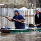 Jackson, Mississippi homeowners use shovels to work their way through Pearl River floodwater.
